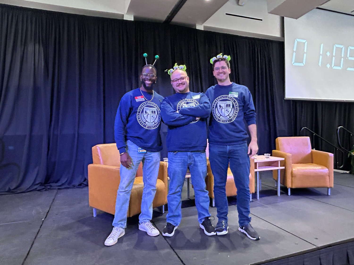 Camilo, Mike, and Kieron on stage before the game, in Zorbitronian antenna headbands